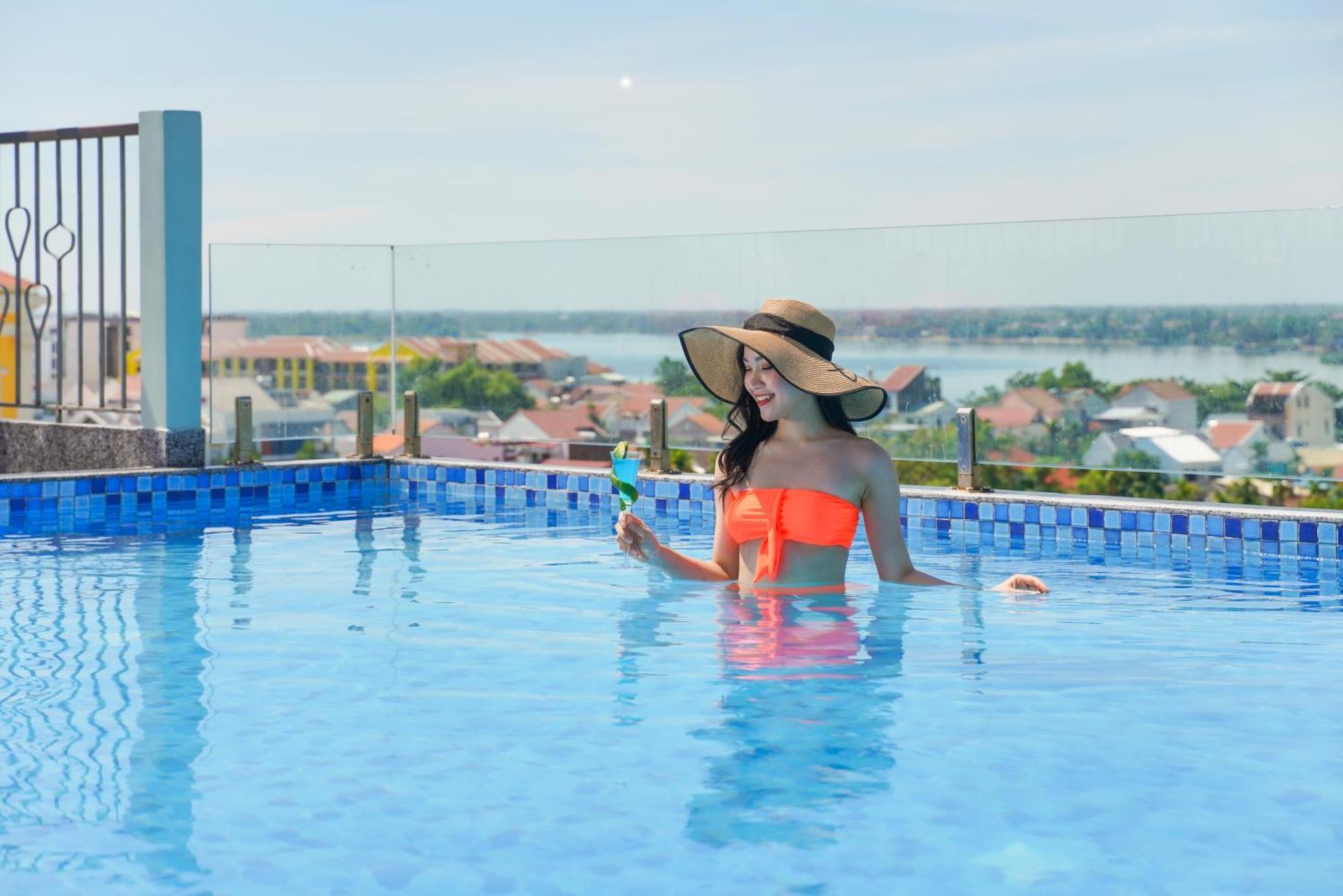 Cozy Savvy Boutique Hotel Hoi An Bagian luar foto A woman in a swimming pool